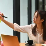 young-woman-using-phone-while-sitting-table